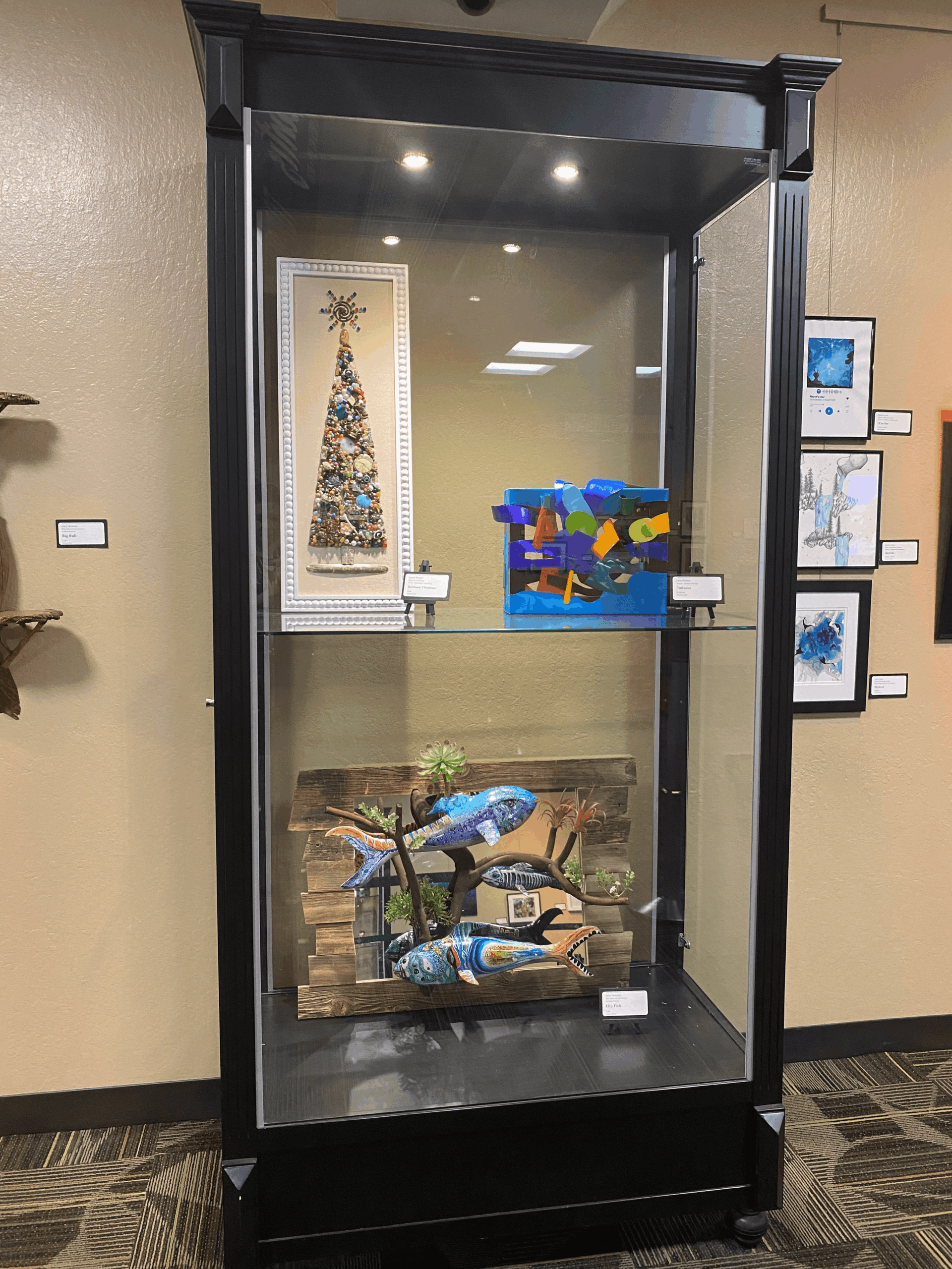 Employee Art show display case holding various art pieces.