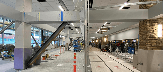 Side by side view of ticketing hall with construction wall splitting the frame