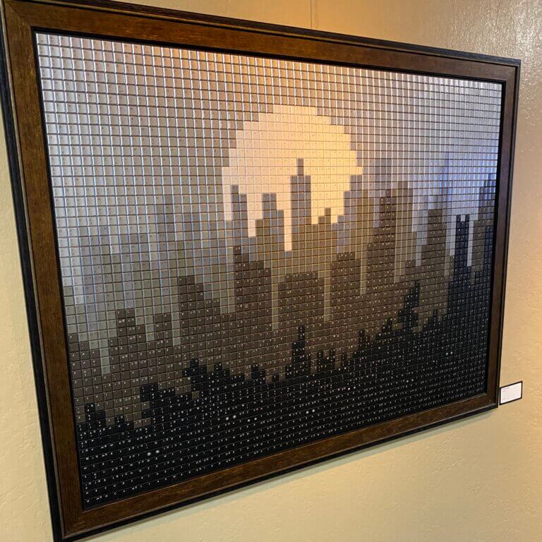 Photo of framed art depicting a skyline made of keyboard pieces.