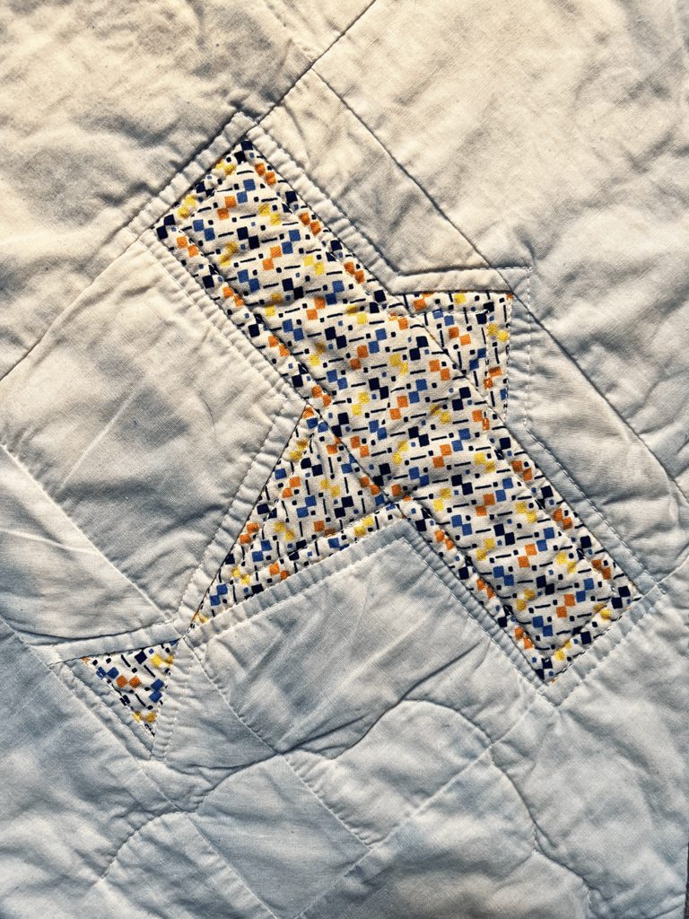 Up close photo of quilt featuring an airplane icon