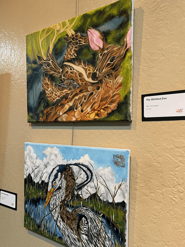 Two art pieces hanging on gallery wall