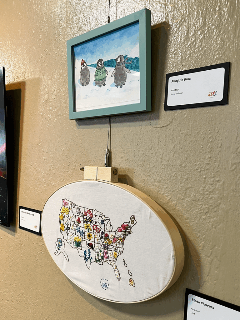Two art pieces hanging on gallery wall