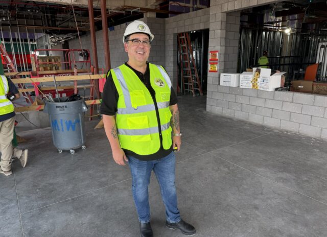 Jason Holescher, artist, stands in the HQ construction site where he will install his artwork in the interior entryway lobby.