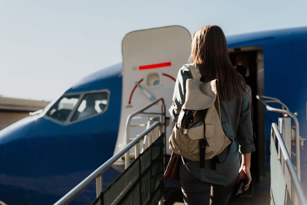Exterior photo of a woman boarding a plane on a sloped ramp